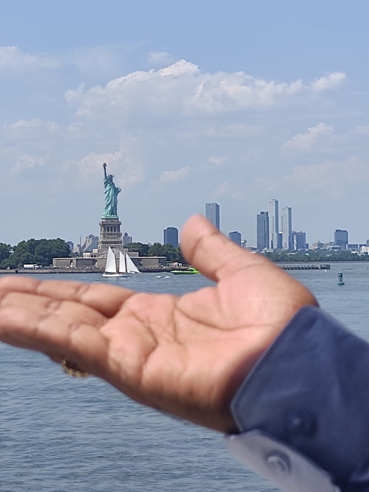 Open hand with Statue of Liberty in background